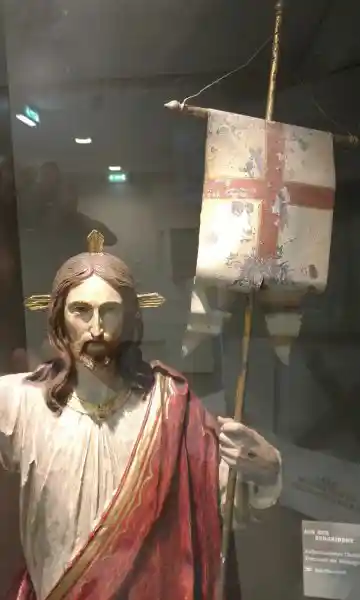 Statue of Jesus with three-point rays on the head holding victory flag